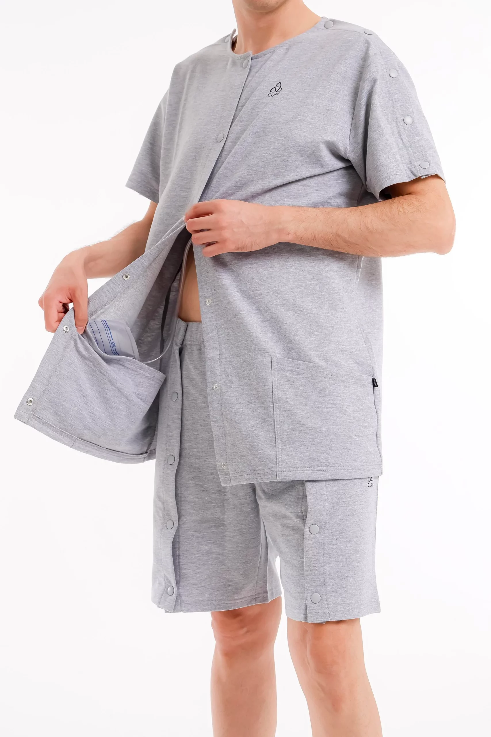 Cure Adaptive Pflegekleidung – graues Unisex-Set mit seitlich geöffneter Front und integrierter Tasche.