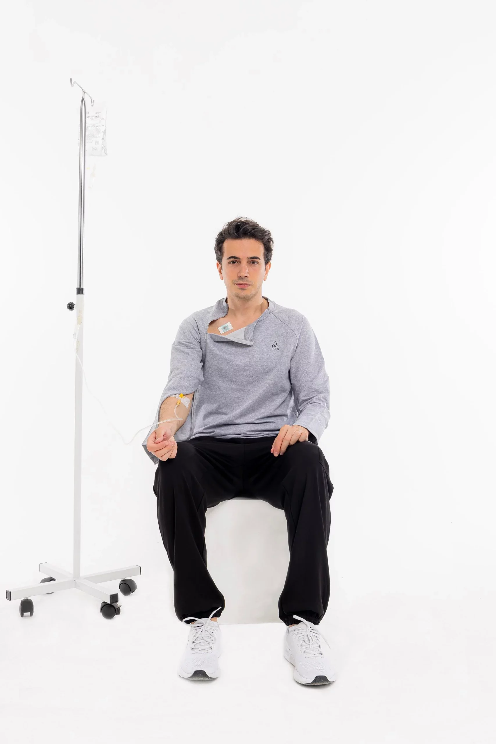 Cure Adaptive Chemotherapie-Behandlungskleidung – Graue Herrenansicht im Sitzen mit Infusion